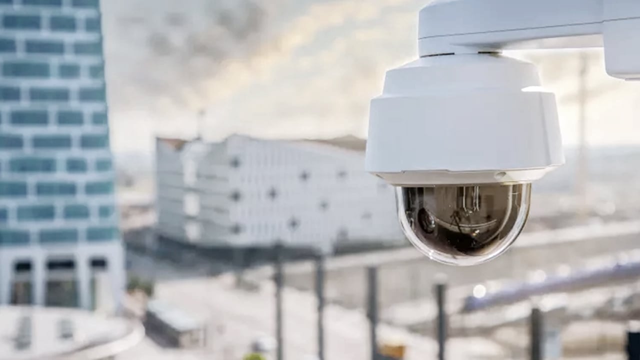 A PTZ (pan-tilt-zoom) CCTV camera surveying a Brisbane city skyline from above.