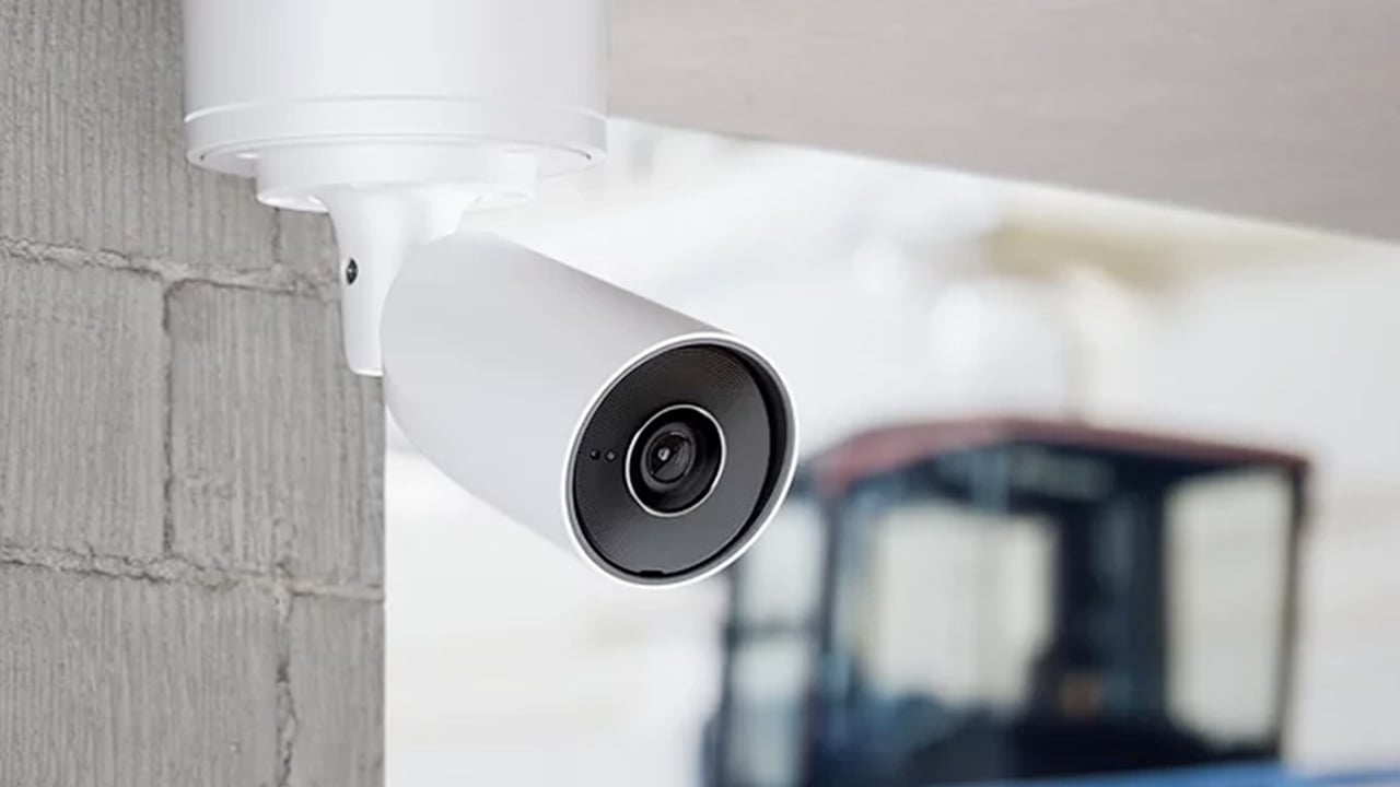 A white bullet-style security camera mounted on an exterior wall.